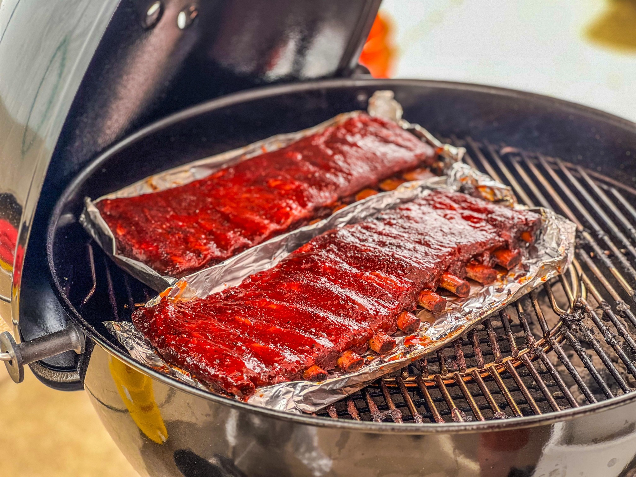 Glazed racks of ribs cooking on a barbecue
