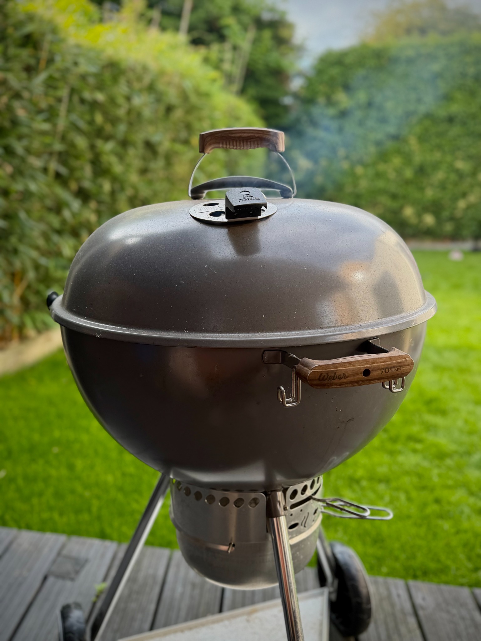 Smoke rising from a closed kettle barbecue